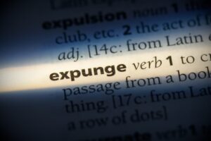 Dictionary entry for the word “expunge” highlighted by a beam of light